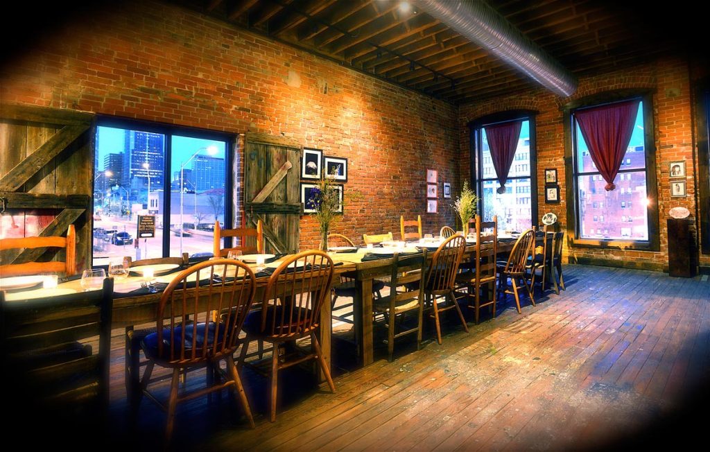 Anton's Taproom with long table, wooden chairs, large windows looking at street below